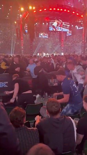 A fan was dropped (left) as a number of people were seen throwing punches
