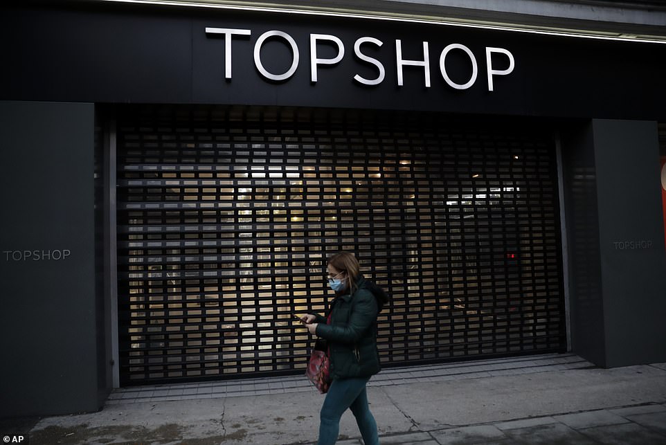 FEBRUARY 2021: A woman wearing a face mask walks past the closed Topshop store in Oxford Street during England's third national lockdown of the Covid pandemic