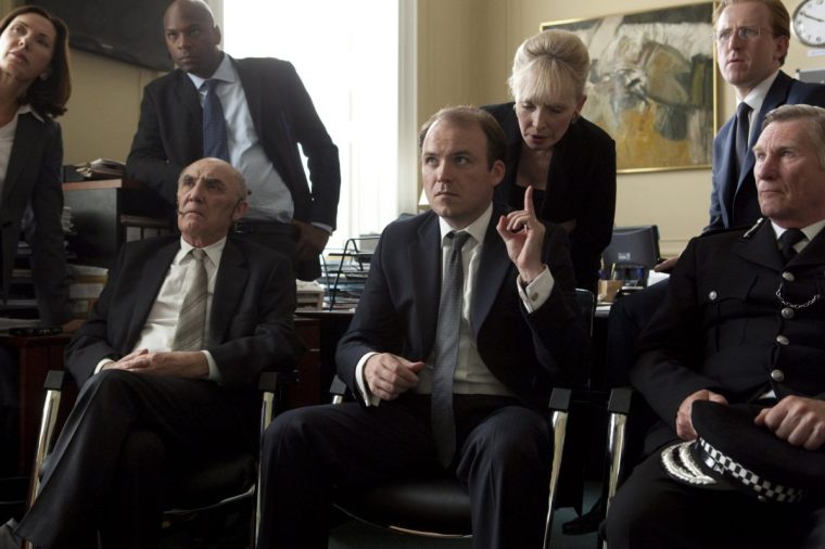 Television programmes: Black Mirror: National Anthem. Julian Hereford (Donald Sumpter) and Michael Callow (Rory Kinnear) Behind Prime Minister Michael Callow is Alex Cairnes (Lindsay Duncan) and Tom Bilce (Tom Goodman-Hill). The man in uniform, the woman far left and the man next to her standing are all extras.