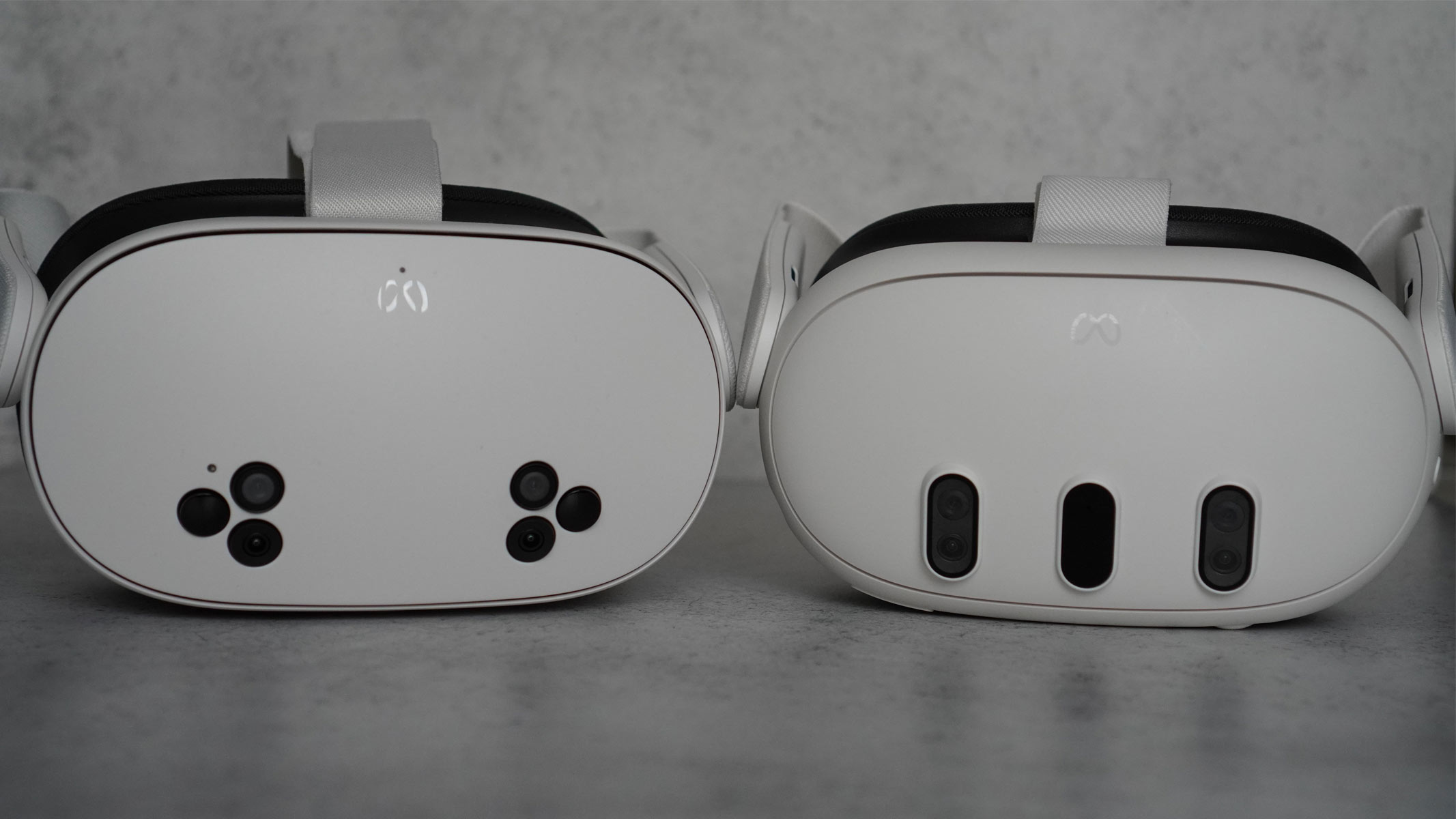 The Meta Quest 3S is a white headset with black cameras on the front and white controllers on a gray background
