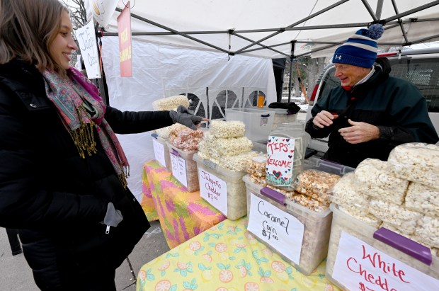 Julie Codling, left, tries out popcorn made by Alan Martens...