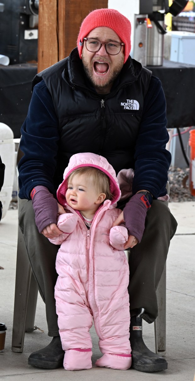 Lily Hamann, 1, and her father, Jeremy, listen to the...