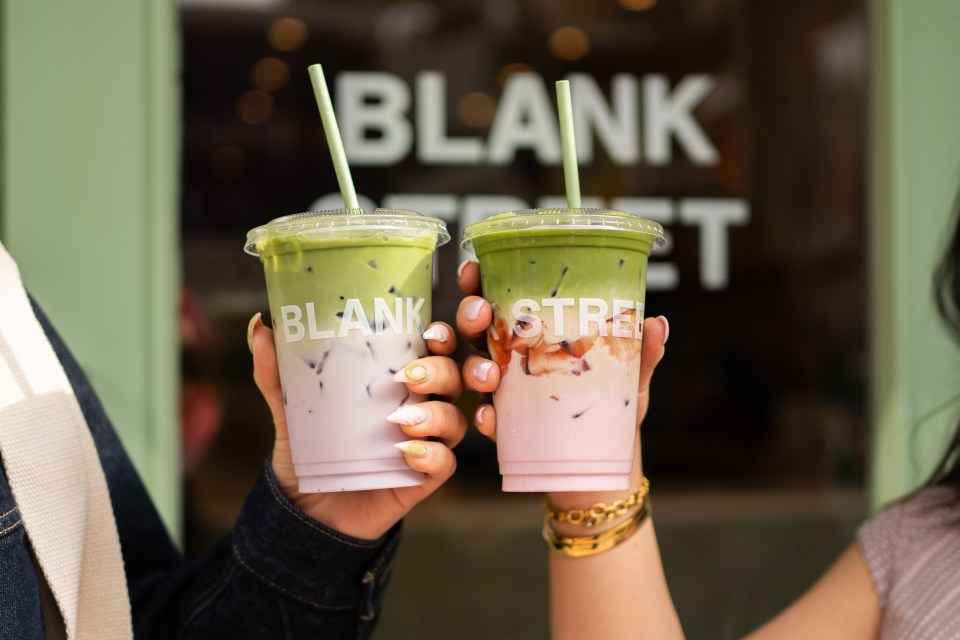 Two people holding up matcha lattes with a pink layer.