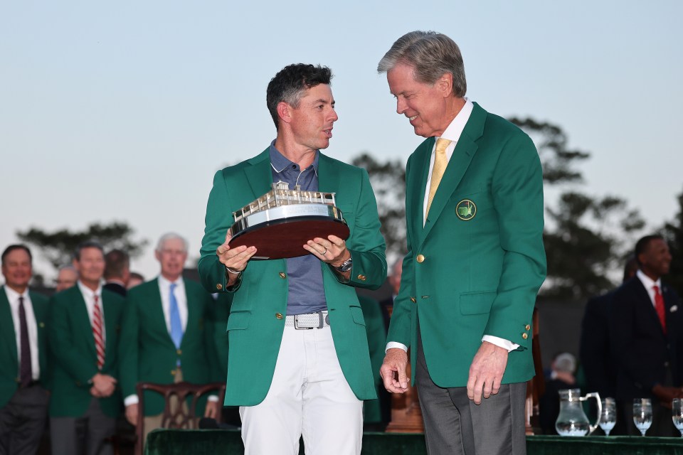 AUGUSTA, GEORGIA - APRIL 13: (R-L) The trophy is awarded by Fred Ridley, Chairman of Augusta National Golf Club, to Rory McIlroy of Northern Ireland after the final round of the 2025 Masters Tournament at Augusta National Golf Club on April 13, 2025 in Augusta, Georgia. (Photo by Michael Reaves/Getty Images)
