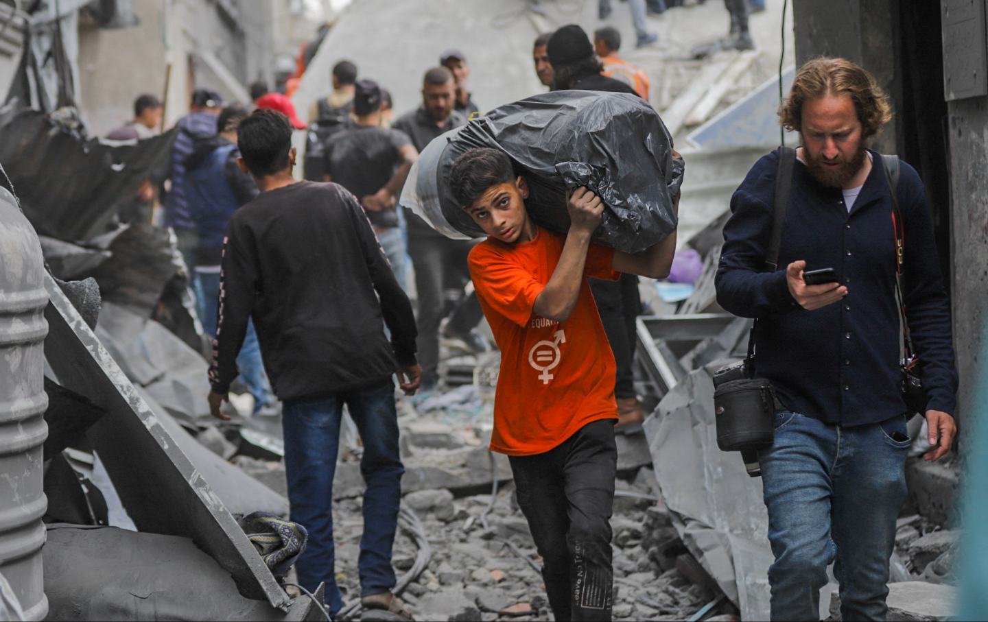 People walk among the rubble of the residential buildings targeted in Israel's attack in Gaza, Palestinian territories on April 9, 2025.