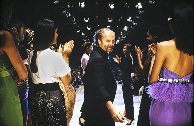 Gianni Versace on the runway with models wearing his designs