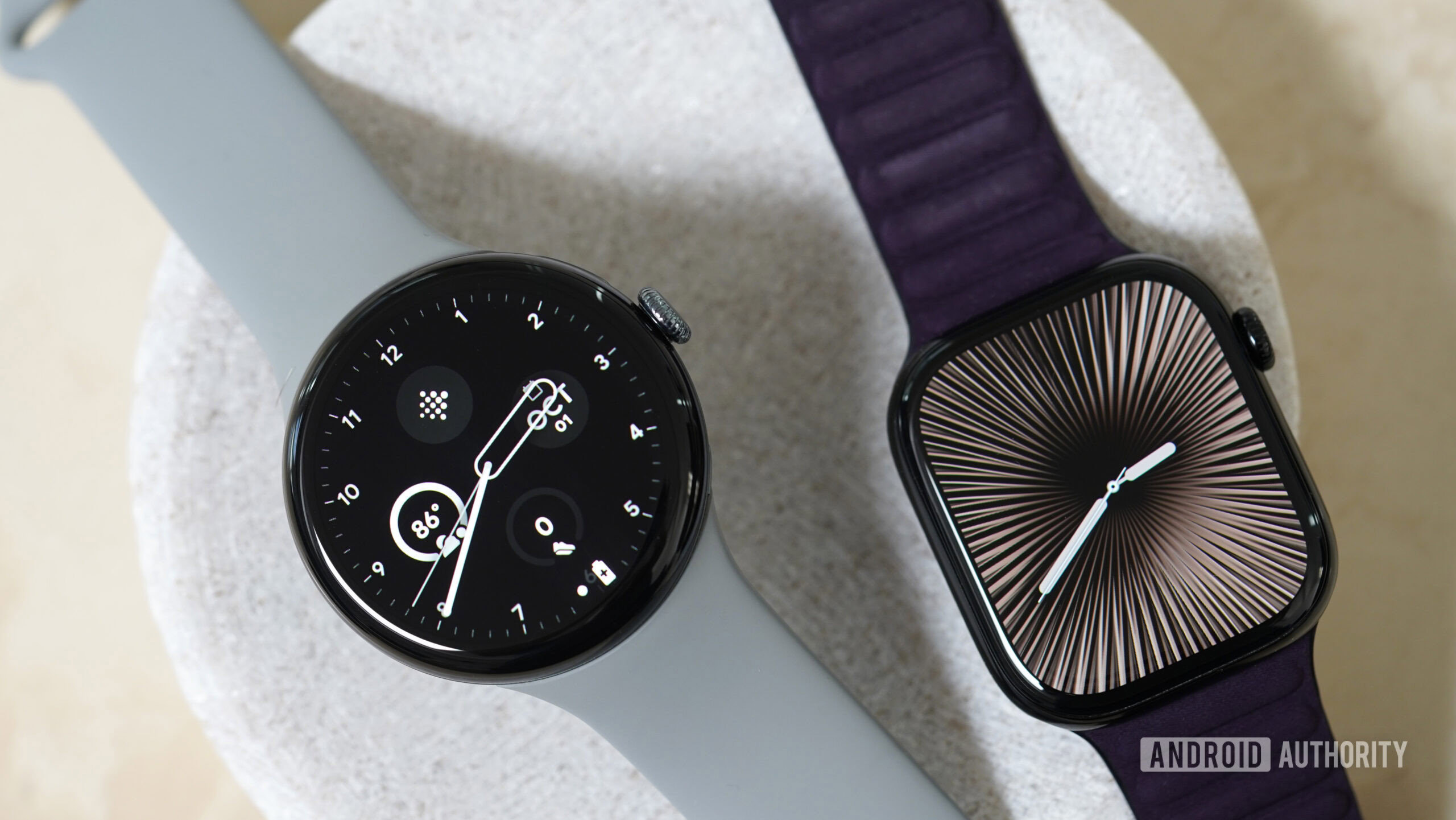 Google Pixel Watch 3 Apple Watch Series 10 A Google Pixel Watch 3 and an Apple Watch Series 10 rest on a stone dish.