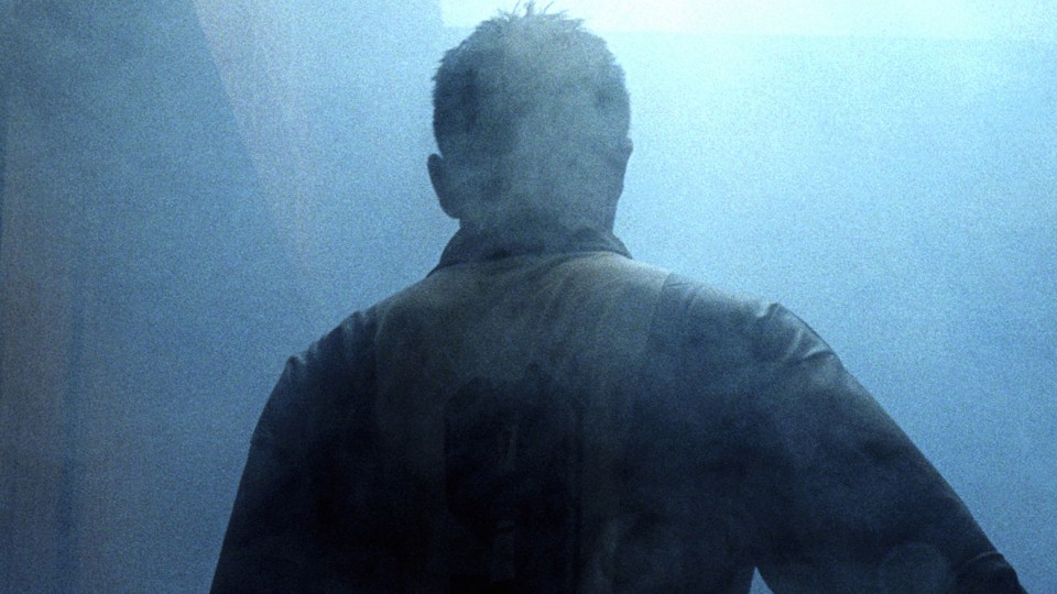 Man from behind in smoky setting.