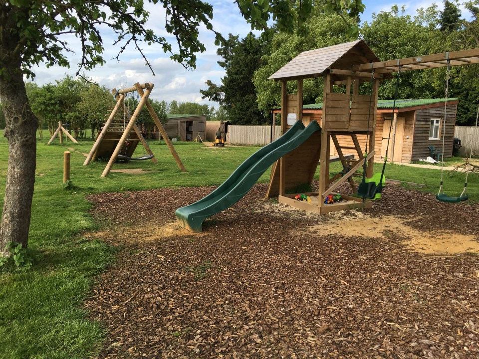 Playground with wooden play structures and a slide.