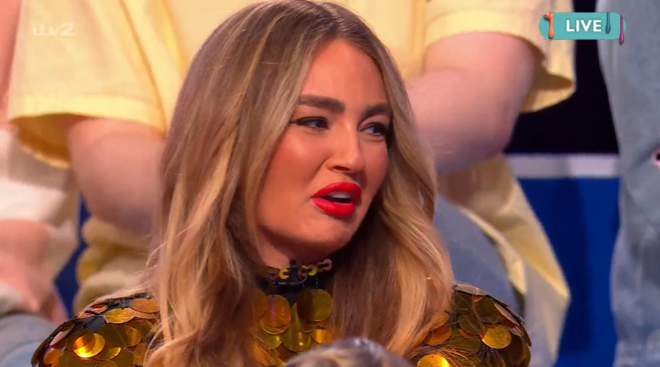 Woman with long blonde hair and gold sequined top speaking on a live TV show.