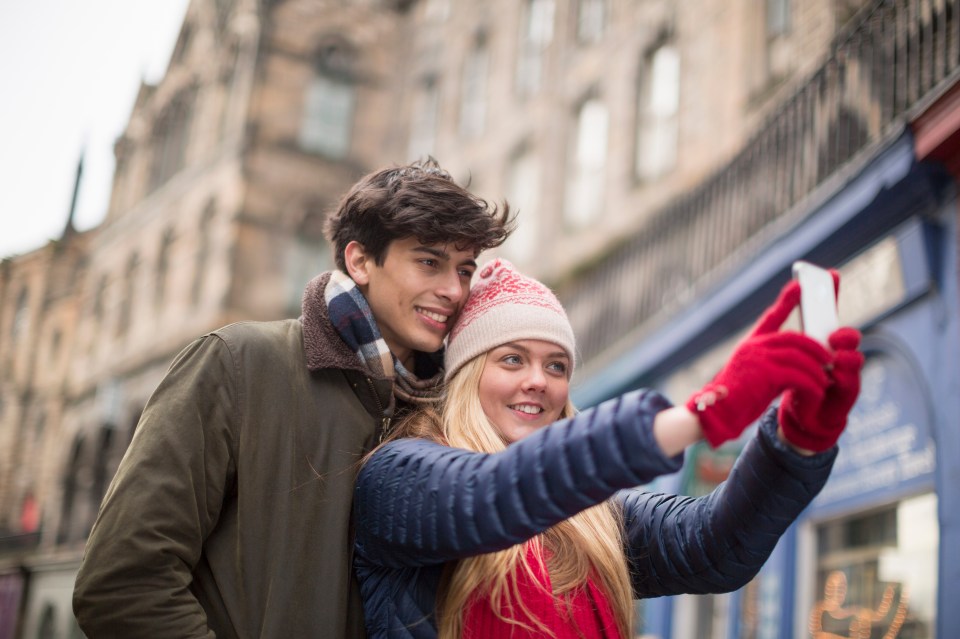 Young couple taking a selfie in a city.