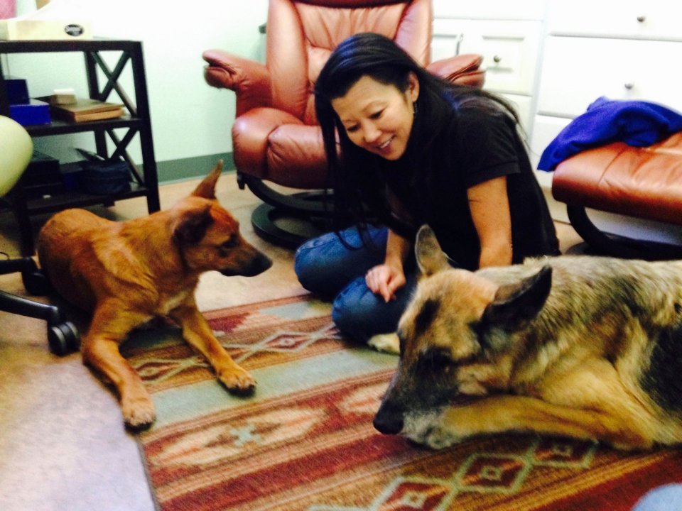Woman sitting on the floor with two dogs.