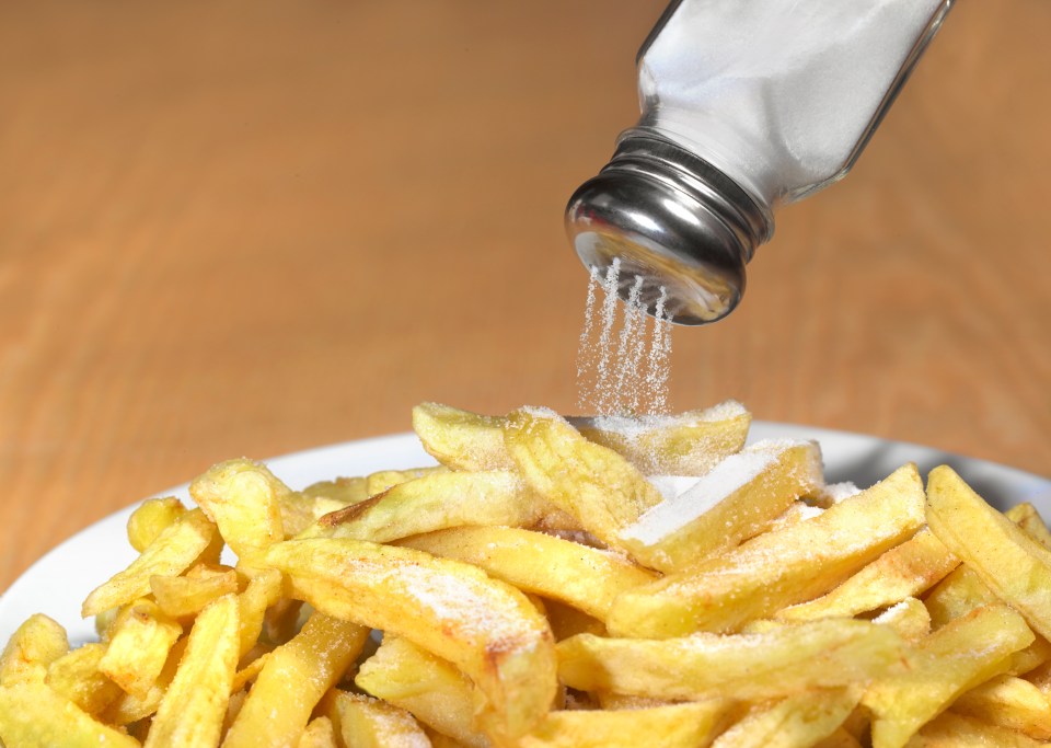 Salt being poured onto french fries.