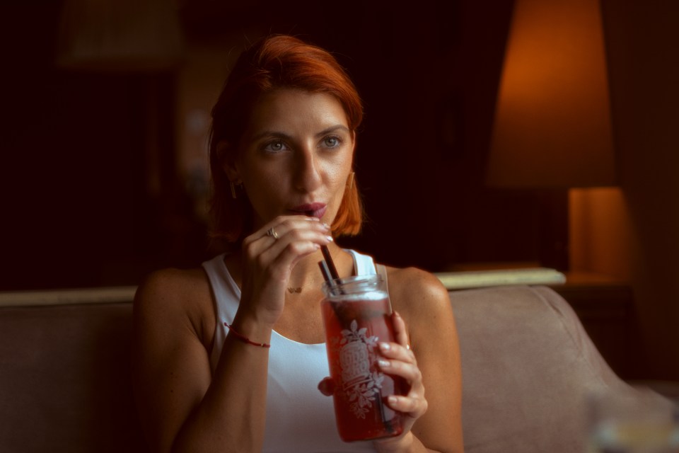 Woman sitting and drinking juice.