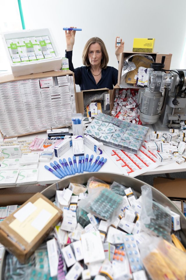 Photo of a woman holding up confiscated illegal prescription medications.