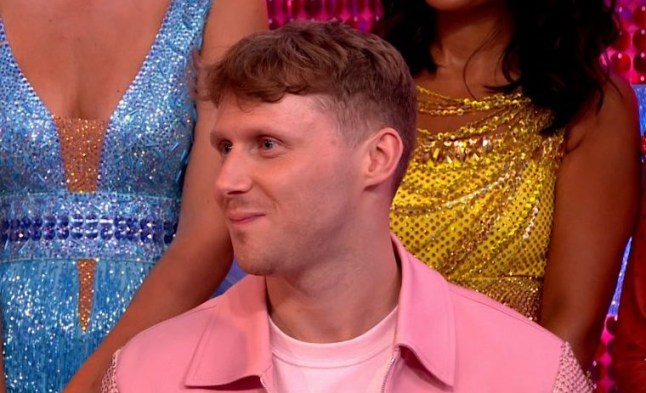 Jamie Borthwick in pink shirt looking away from camera