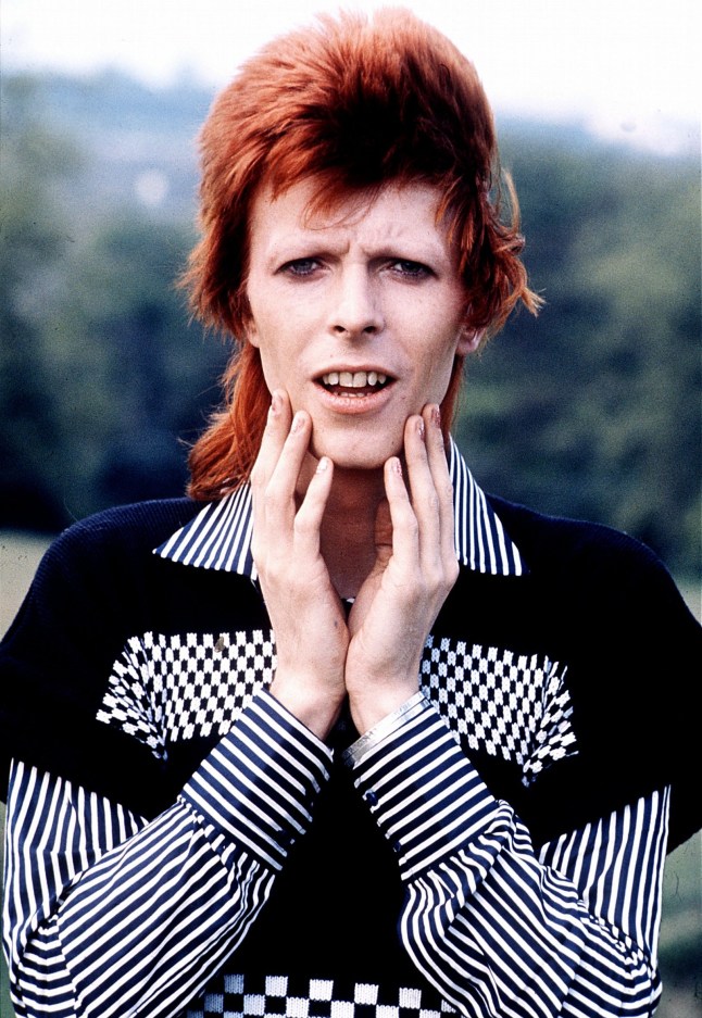 David Bowie pictured in 1973 wearing a black and white suit shirt.