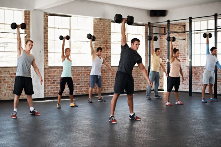 Shot of a group of people lifting dumbbells in a fitness class