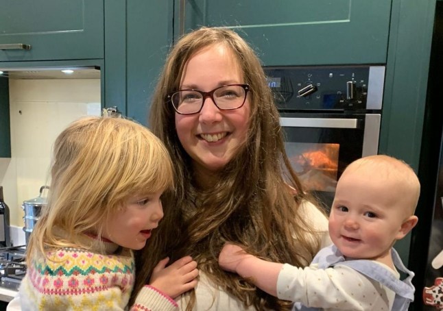 Alex Meyer smiles while holding her two children
