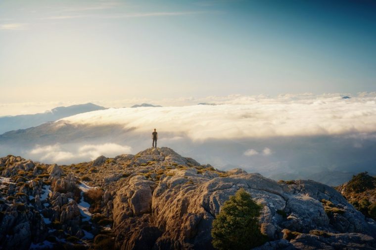 A solitary figure stands at the peak of Sierra de las Nieves National Park, taking in the breathtaking vista spread out before them. With the vast expanse of the horizon stretching endlessly, they contemplate the wonders of nature.