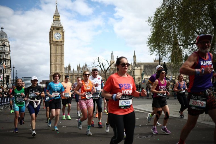 Fun runners compete near the Houses of Parliament during the 2024 London Marathon in central London on April 21, 2024. (Photo by HENRY NICHOLLS / AFP) / 