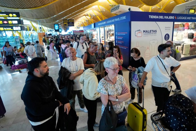 Passengers queue inside Madrid airport, during a nationwide power outage, Monday, April 28, 2025. (AP Photo/Manu Fernandez)