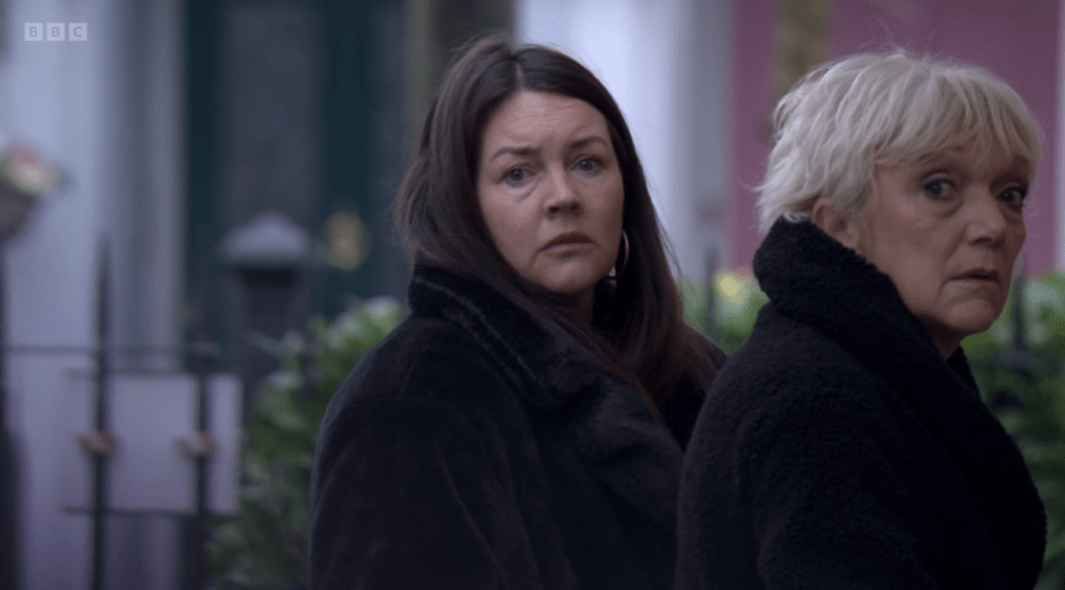 Screenshot of two women in dark coats.