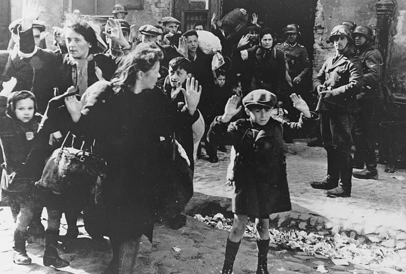 A group of Jews is escorted from the Warsaw Ghetto by German soldiers, 19 April, 1943