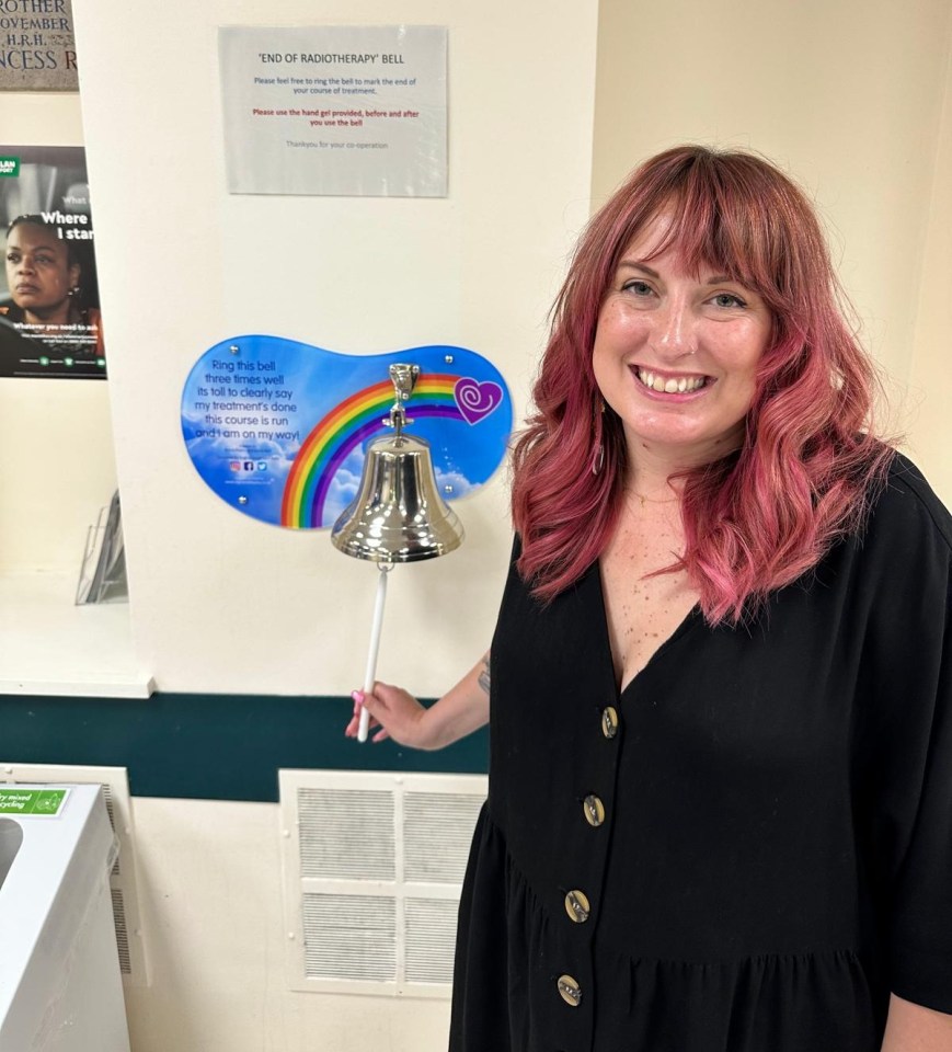 Woman ringing end-of-radiotherapy bell.