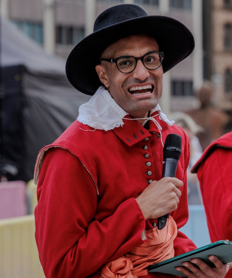 Richie Anderson in 17th-century soldier costume holding a microphone and tablet.