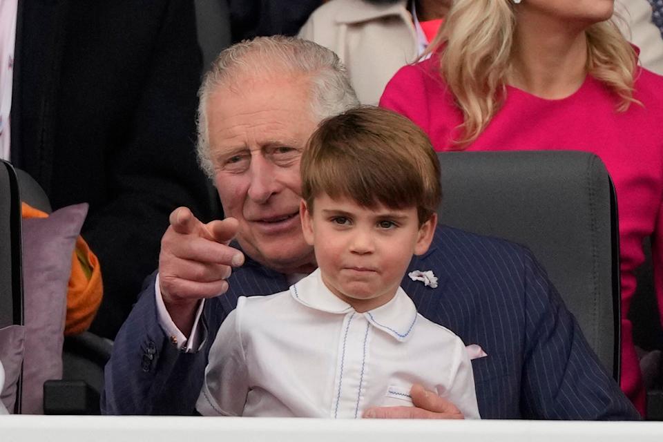 King Charles sitting with Prince Louis on his lap and pointing