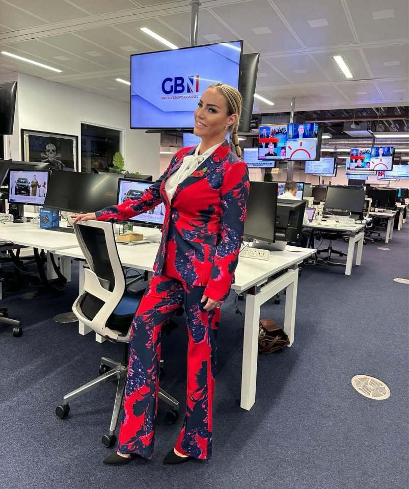 Woman in red and black floral pantsuit at news channel office.