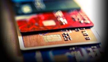 Close up macro color image depicting an abstract view of a collection of debit and credit cards and numeric digits.