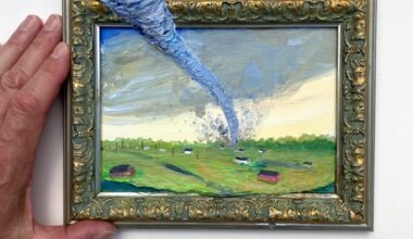 a small picture frame depicting a landscape with a tornado. the funnel cloud protrudes from outside of the frame