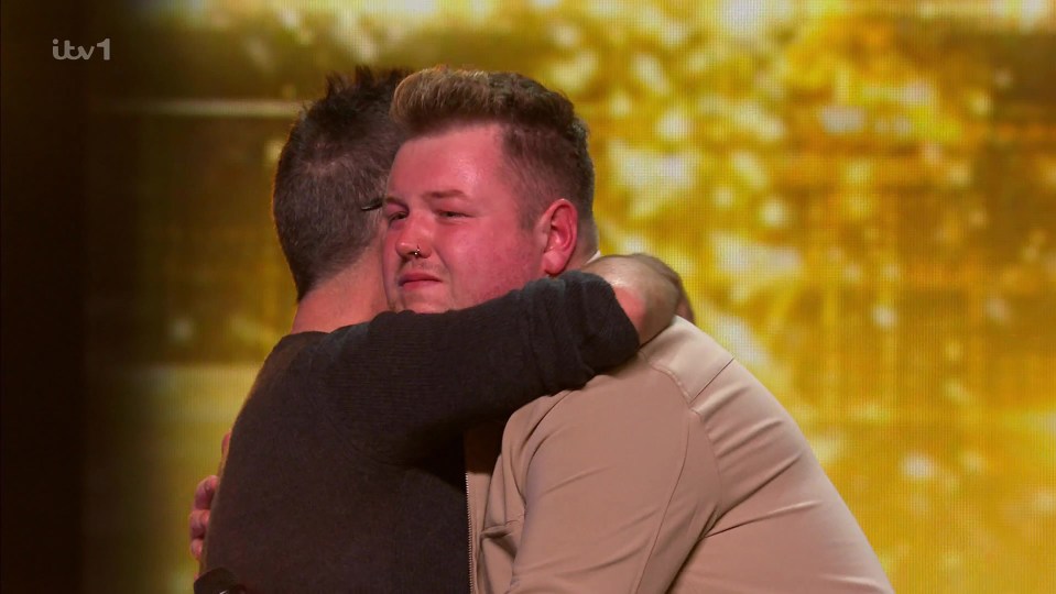Two men hugging after a talent show performance.