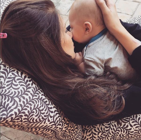 Woman holding and nuzzling baby.