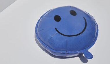 a ceramic sculpture of a blue happy face balloon