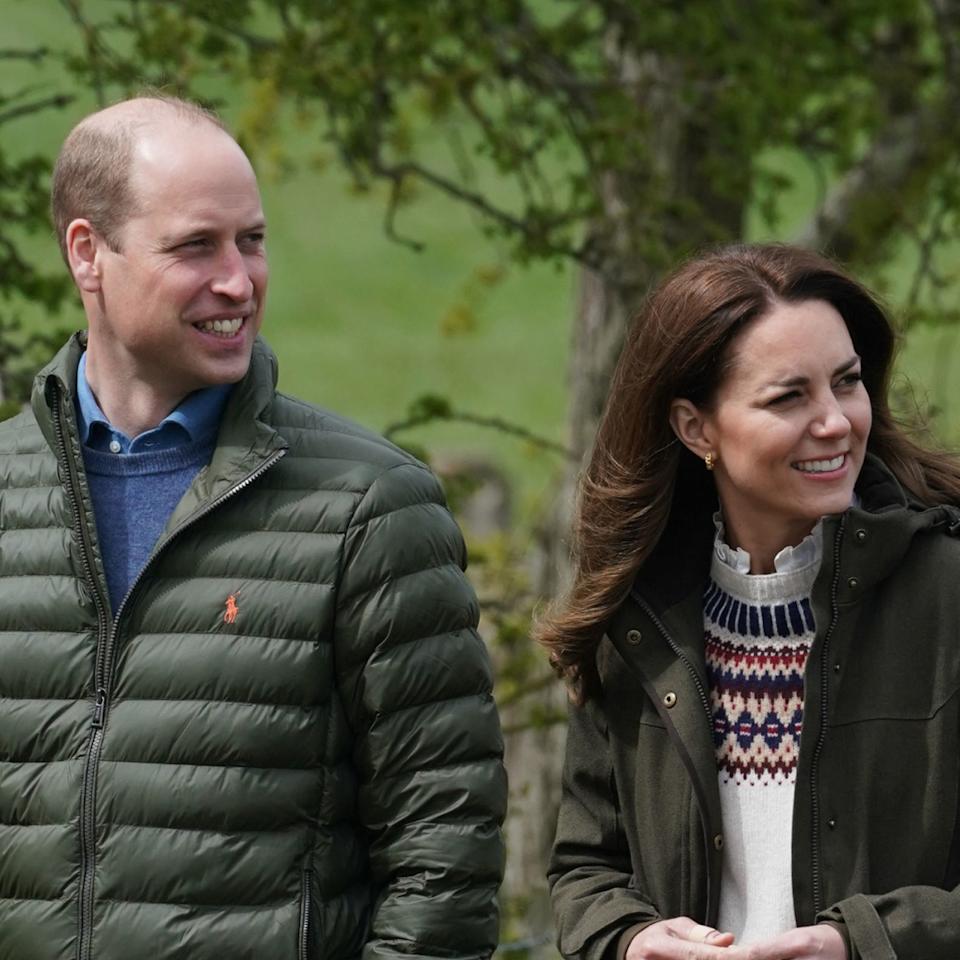  Prince William and Kate Middleton wear matching dark green coats for a walk. 