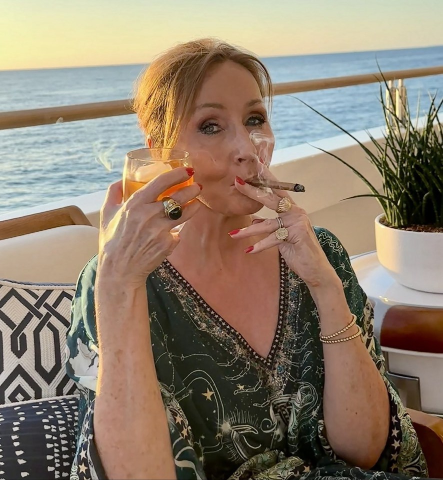 Woman smoking a cigar and drinking a cocktail on a yacht.