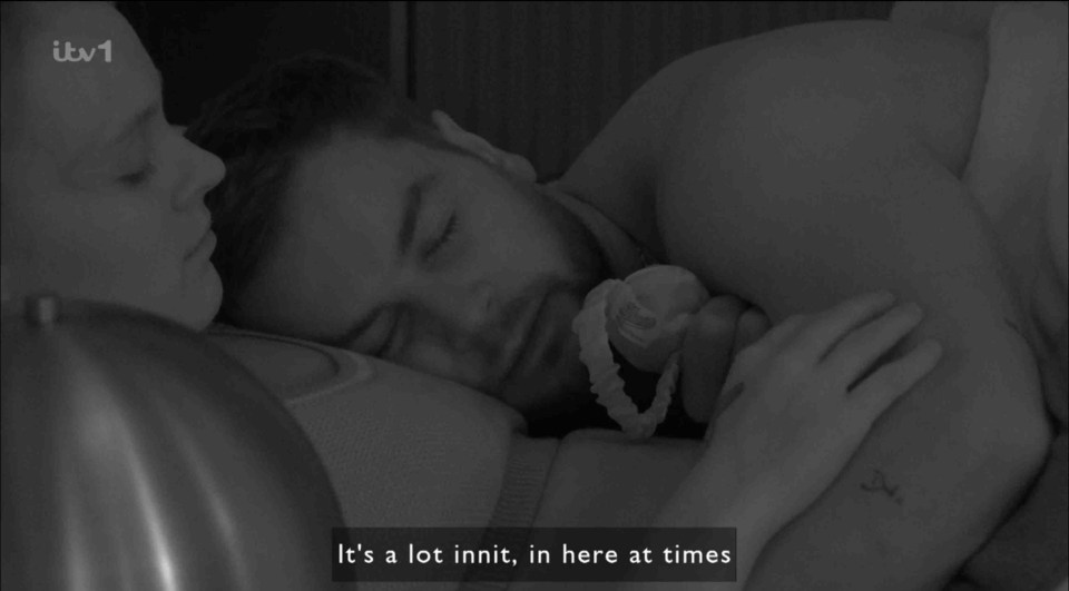 Black and white still image of JoJo Siwa and Chris Hughes in bed together.