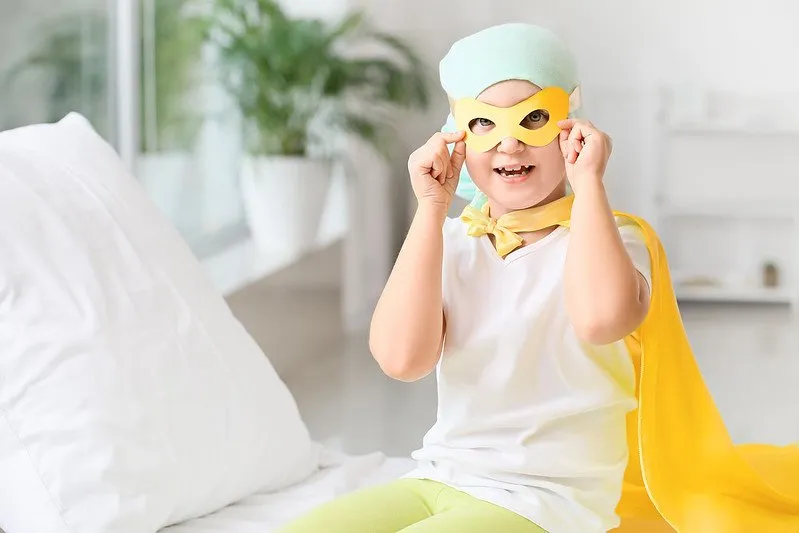 Child cancer patient wearing a superhero costume in hospital.
