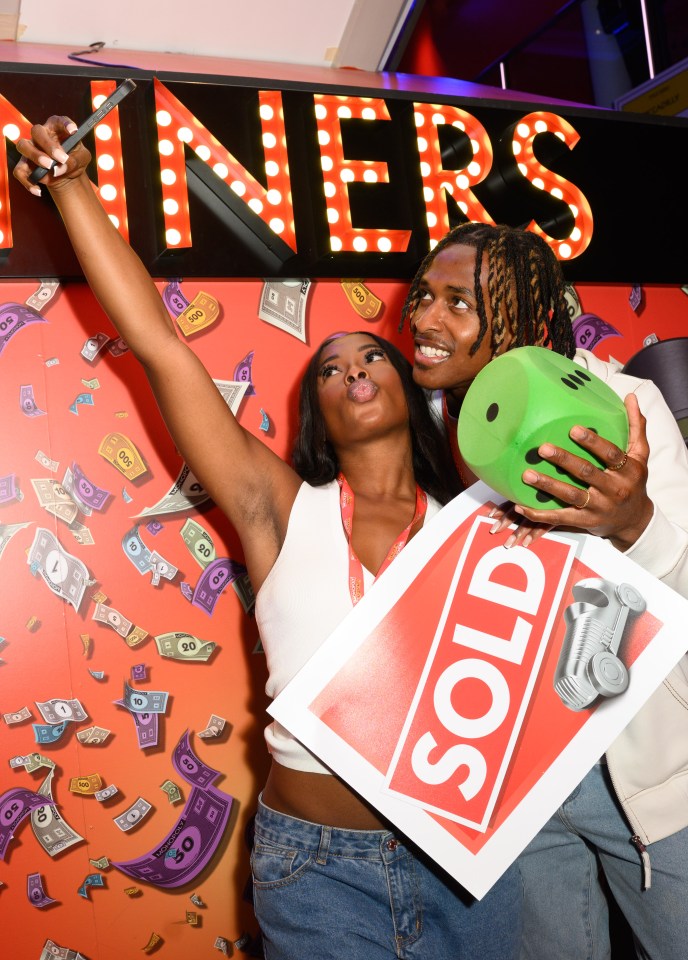 Two people at a Monopoly event taking a selfie.