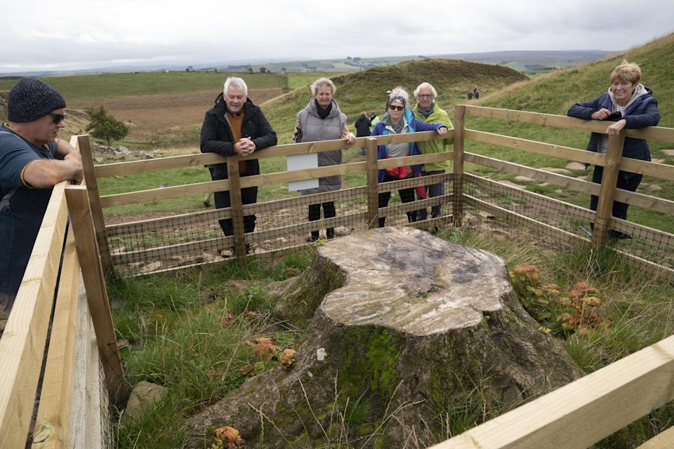 EMBARGOED TO 0001 FRIDAY SEPTEMBER 27 People gather around the stump of the Sycamore Gap tree in Northumberland National Park. The 
