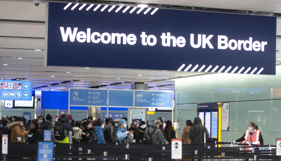 People queuing at UK border control in Heathrow Airport.
