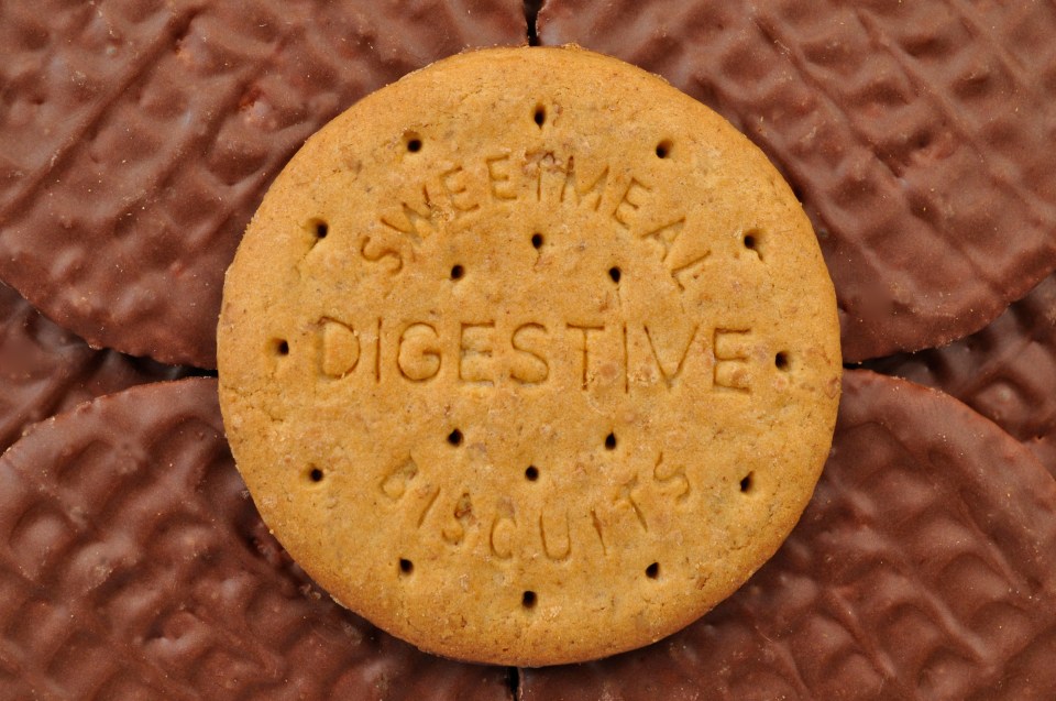 Chocolate-covered digestive biscuit on a bed of similar biscuits.