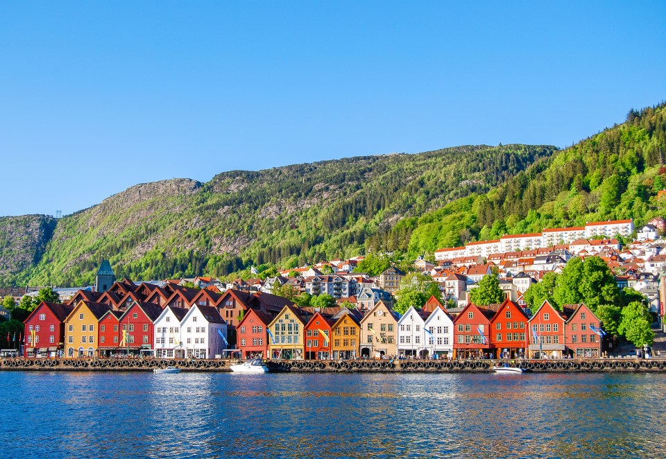 Colorful timber houses reflected in the Nidelva River, Trondheim, Norway.