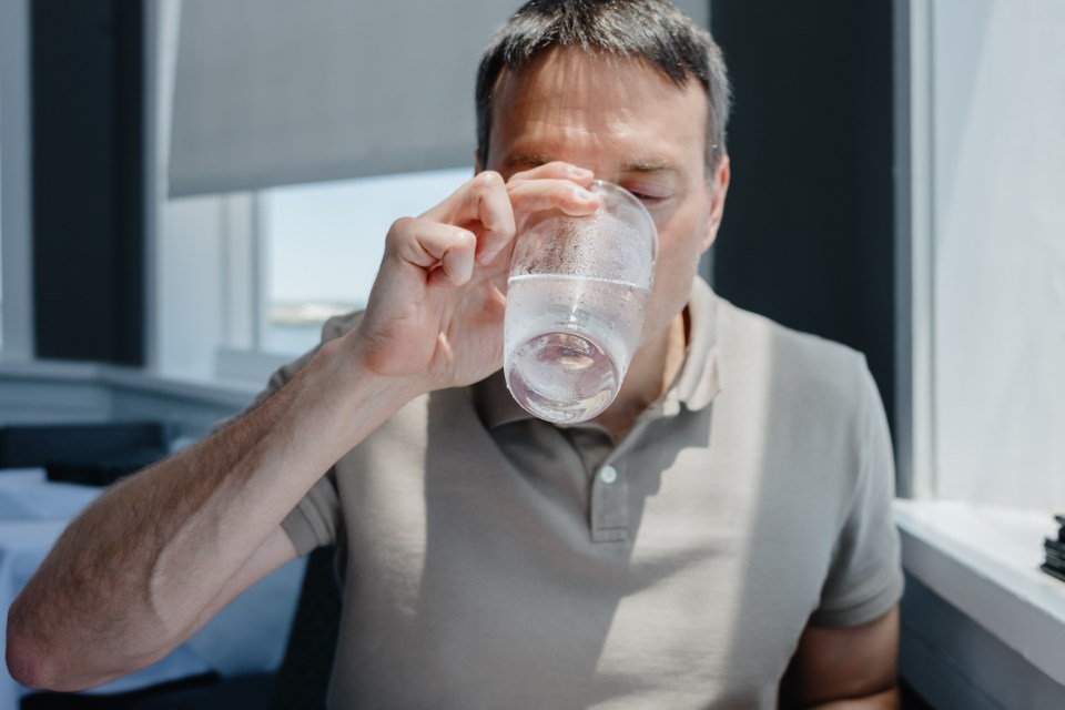 Man drinking water at a restaurant.