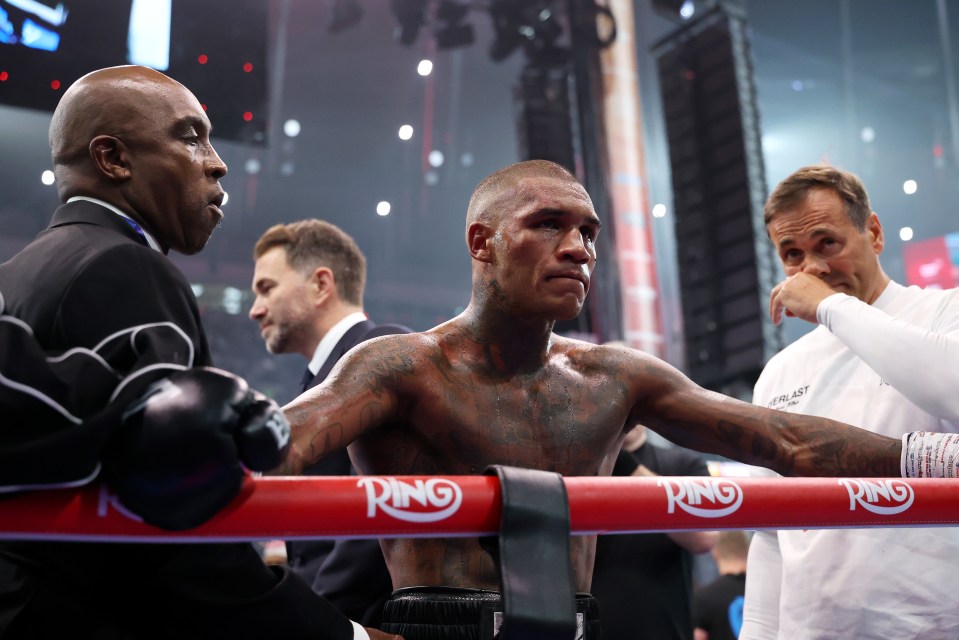 Conor Benn looking dejected after a boxing match, with his father Nigel Benn beside him.
