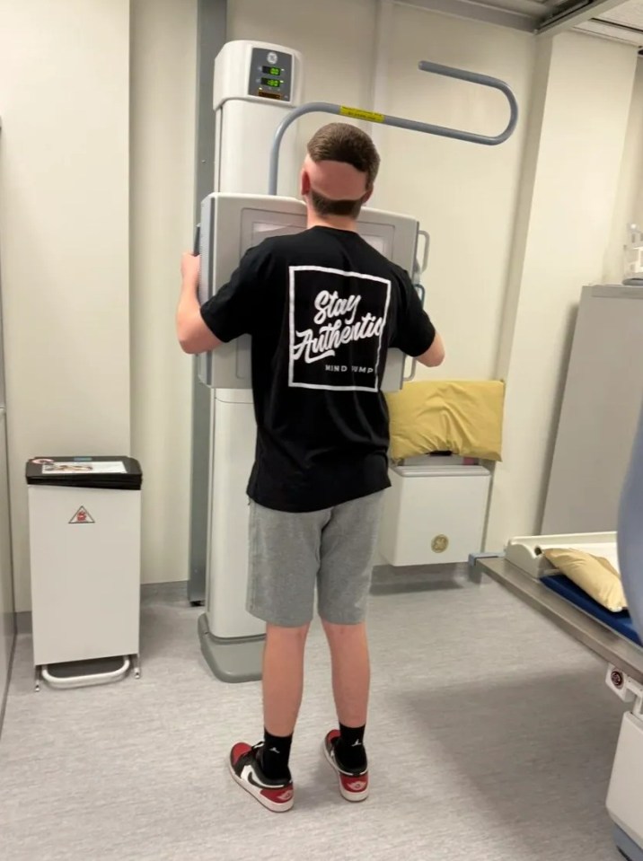 Person standing facing away from the camera, positioned for an X-ray.