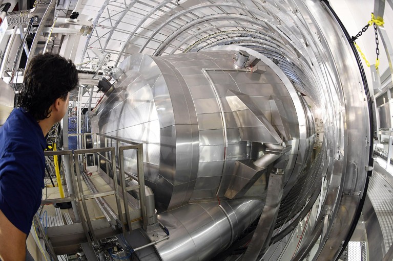 A Karlsruhe Tritium Neutrino Experiment researcher looks into the main spectrometer of the device at the Karlsruhe Institute for Technology.